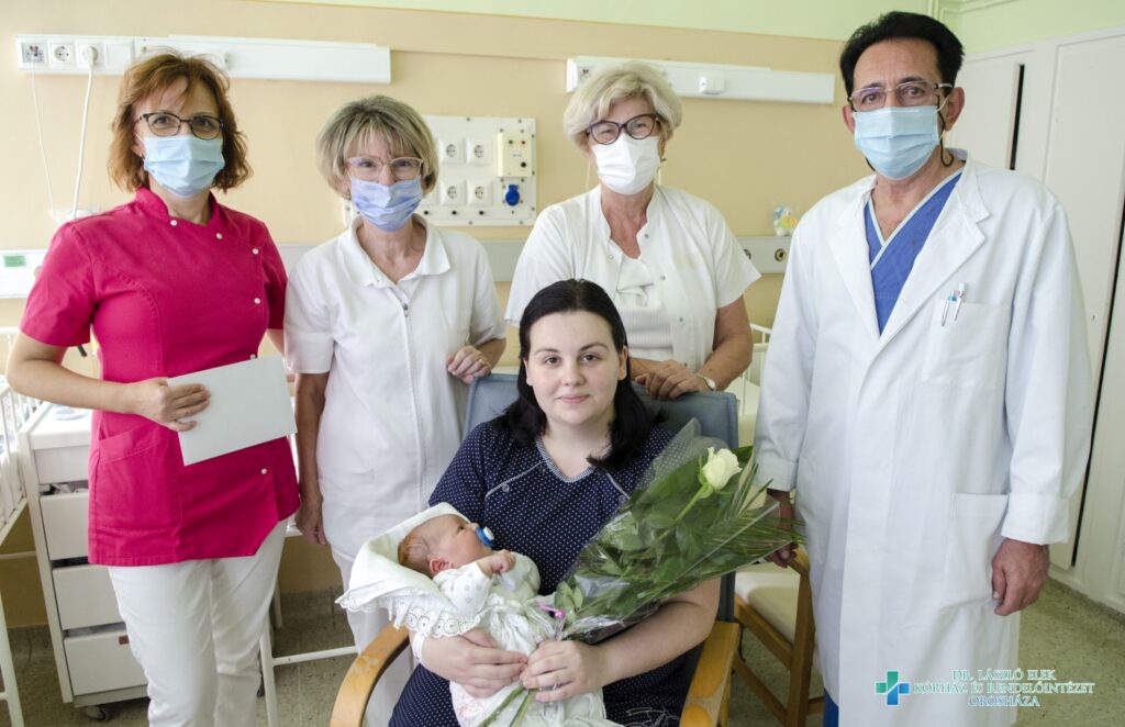 A képen: a Szülészet Nőgyógyászati Osztály nevében Hevesi Ágnes (b1) főnővér és dr. Svarsnig Lajos (j2) osztályvezető főorvos, a Csecsemő- és Gyermekosztály nevében dr. Kováts Anikó (b2) osztályvezető főorvos és dr. Kalydi Antónia (j1) főorvos köszönti a büszke anyukát és a kisfiút.
Fotó: Melega Krisztián/Dr. László Elek Kórház)